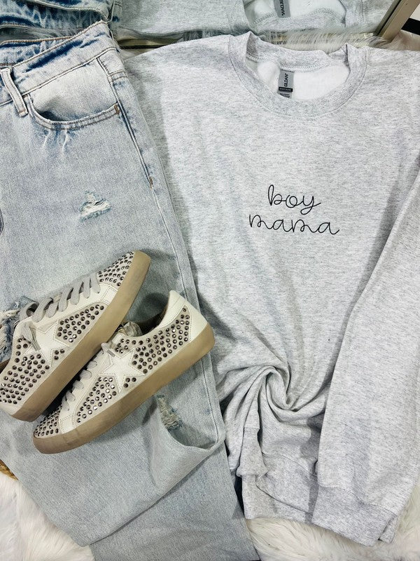 A gray sweatshirt with the text 'BOY MAMA' embroidered on the front, paired with blue jeans and white sneakers with embellishments on the sole.