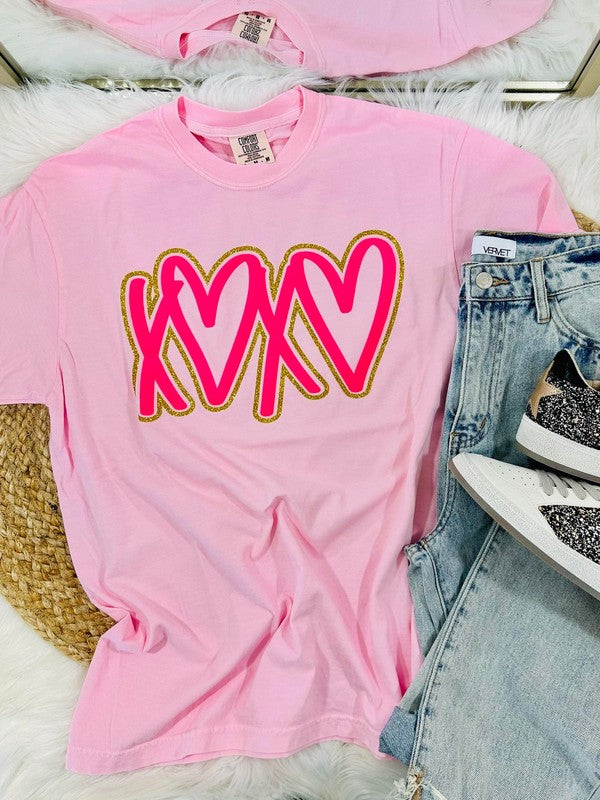 Pink t-shirt with xoxo heart design, jeans, and sneakers on a light background