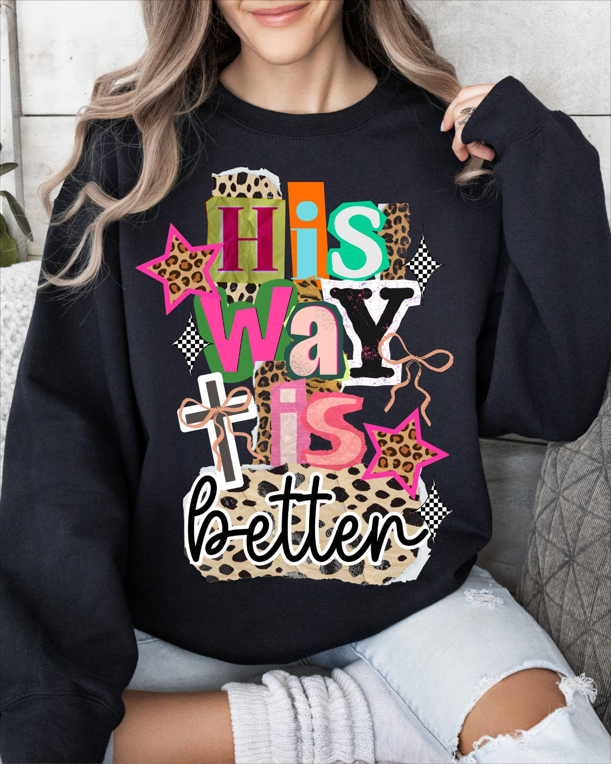 Person wearing a black sweatshirt with colorful text and patterns saying "His way is better" song lyrics